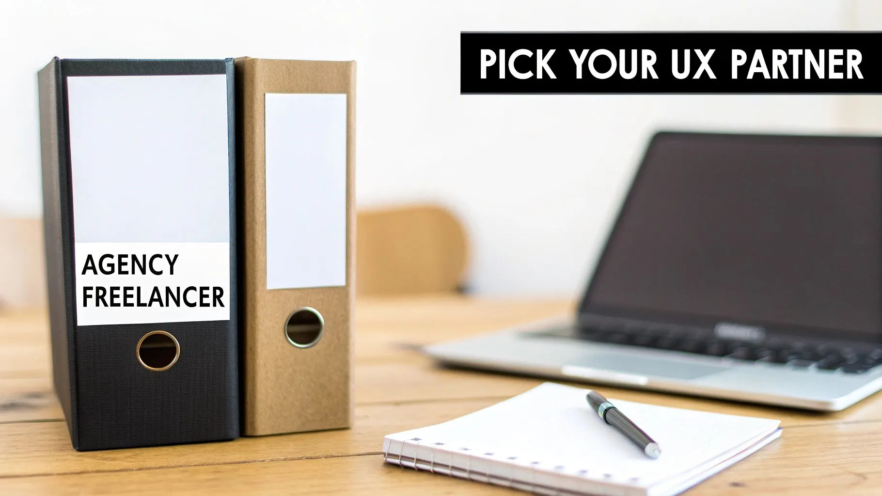 Office desk with folders labeled agency and freelancer next to laptop for UX partner selection